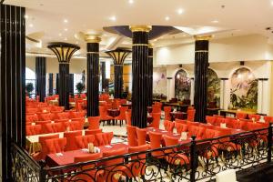 un ristorante con sedie arancioni e tavoli in un edificio di Red Castle Hotel a Sharjah