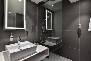 
a bathroom with a sink, mirror, and bathtub at Novotel Wavre Brussels East in Wavre

