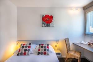 Les Orchidées , Hôtel & Restaurant في فردان سور ميوز: غرفة نوم مع سرير مع وردة حمراء على الحائط
