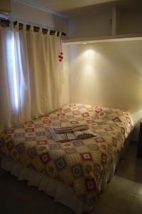 1 dormitorio con 1 cama con cortina y ventana en Departamentos en Salta en Salta