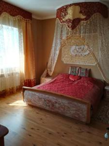 1 dormitorio con cama con dosel y ventana en Готель Алекс, en Lutsk