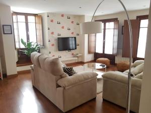 a living room with two chairs and a flat screen tv at Apartamento Cine Colón in Ribadeo