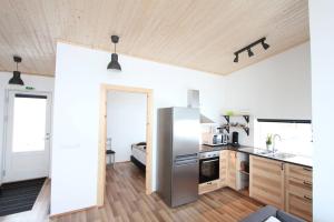 una cucina con frigorifero in acciaio inossidabile e mobili in legno di Blue View Cabin 4A With private hot tub a Reykholt Altre 6 foto
