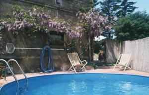 a swimming pool with two chairs and a slide at Casa Portone Paola in Campiglia dʼOrcia