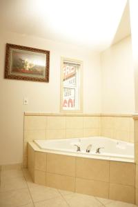 La grande salle de bains est pourvue d'une baignoire et d'une peinture murale. dans l'établissement Chateau Motel, à Edmonton