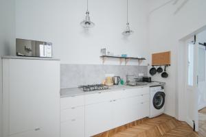 a white kitchen with a stove and a sink at Lizmary's Wonderland in Budapest