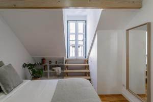 um quarto com uma cama branca e uma escada em City Escape- Apartment In a Quiet Corner of the City em Lisboa