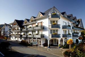 a large white building with black roof at Hotel Hochheide in Willingen