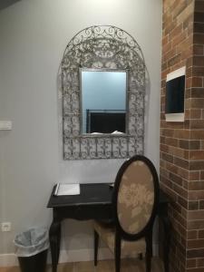 a mirror on a wall with a table and a chair at Amaryllis in Nafpaktos