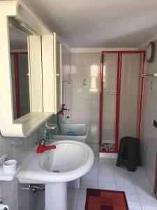 y baño con lavabo blanco y ducha. en Marielle Maison, en Santo Stefano di Camastra