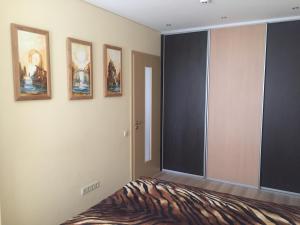 a bedroom with a bed and some pictures on the wall at Saulėti apartamentai in Palanga +2 photos