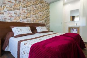 1 dormitorio con 1 cama grande con manta rosa en Pension ARCA, en O Pedrouzo