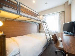 a bedroom with a bunk bed and a desk with a computer at Super Hotel Lohas Kumamoto Natural Hot Springs in Kumamoto