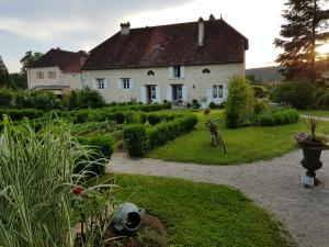 a large white house with a garden in front of it at L'Aumônerie in Liesle