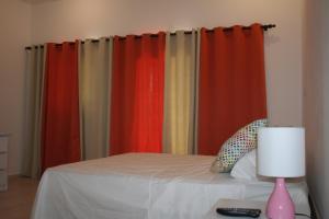 a bedroom with colorful curtains and a bed with a lamp at Apartamentos y Villas Michaela in Sosúa +13 photos