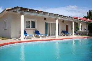a swimming pool with chairs and a house at Villas Michaela Caribbean in Sosúa