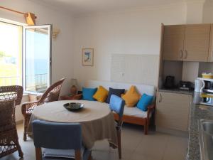 uma sala de estar com uma mesa e um sofá em LAJINHA MAR-BEACH APARTMENT-Zambujeira Mar na Zambujeira do Mar