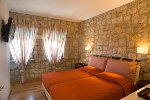 a bedroom with a bed and a stone wall at Blue Dream Luxury Villas in Pefki