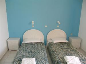 Duas camas num quarto com paredes azuis em Kontessa Apartments em Céfalo