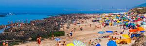 una multitud de personas en una playa con sombrillas en Apartamento da Praia da Amorosa en Amorosa