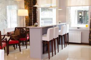 una cucina con bar e sedie bianche di 1412 Hotel Boutique a Rosario