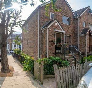 een stenen huis met een hek ervoor bij The Chelsea Apartment in Londen