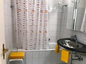 a bathroom with a sink and a shower curtain at Ascona Principessa Apt 3 in Ascona