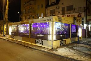 Domin Osijek في أوسييك: حافلة مغطاة بأضواء عيد الميلاد على جانب شارع