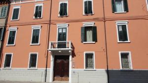 Edificio naranja con puerta y balcón en Centro Storico Rooms en Ferrara