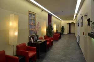 a corridor of a waiting room with red chairs at Hotel Albert II Oostende in Ostend