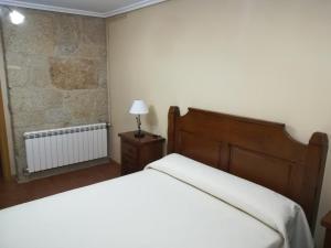 1 dormitorio con cama y pared de ladrillo en Casa Bravo, en Gondomar
