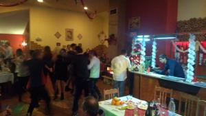 a group of people standing around a bar in a restaurant at Hotel Valdis in Pastra