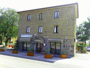 a large brick building with potted plants in front of it at Affittacamere da Laura Silvi in Orvieto