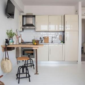 a kitchen with white cabinets and a wooden table at SUNSET LOFT in Livorno