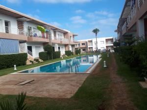 a swimming pool in front of some apartment buildings at Résidence Dreamland in Sidi Rahal
