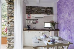 バダルッコにあるAgriturismo l'Adagioの紫の壁のキッチン(テーブル付)