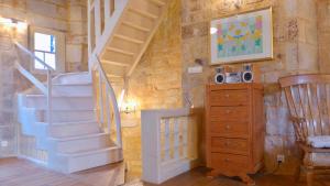 a staircase in a room with a dresser and a cabinet at Rue Bertrand de Got in Saint-Cyprien