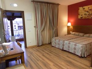 Habitación de hotel con cama y mesa en Hotel Milagros Rio Riaza, en Milagros