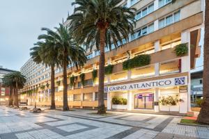 a large building with palm trees and palm trees at Eurostars Atlántico in A Coruña