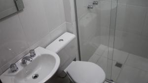 y baño con aseo, ducha y lavamanos. en Hotel Ricardi Express, en Cascavel