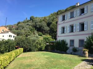 a building with a yard in front of a mountain at Villa CieloMare in Camogli