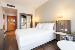 1 cama blanca grande en una habitación de hotel en Eurostars Atlántico, en A Coruña