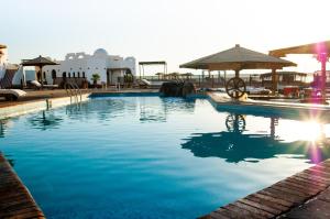 a swimming pool with blue water in a resort at Daniela Diving Resort Dahab in Dahab