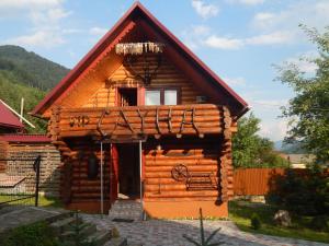 eine Blockhütte mit Veranda und Tür in der Unterkunft BergWind in Russkaya Mokraya