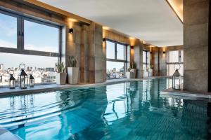 a swimming pool in a building with windows at Alvear Palace Hotel - Leading Hotels of the World in Buenos Aires