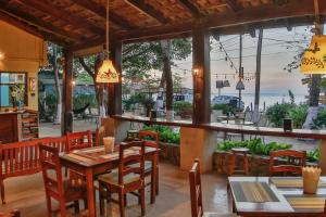 een restaurant met tafels en stoelen en uitzicht op de oceaan bij Rustic Beach Front Hotel Brasilito in Brasilito