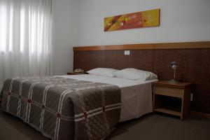 um quarto com uma cama grande e uma cabeceira em madeira em Apto no Union Residence em Novo Hamburgo