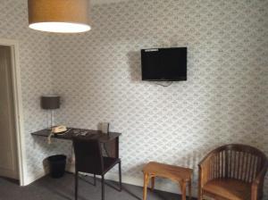 TV a/nebo společenská místnost v ubytování Logis Terrasse Hôtel