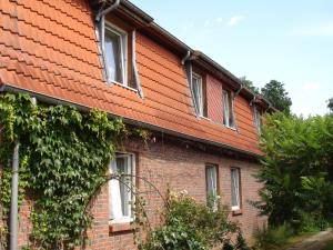 ein rotes Backsteingebäude mit Fenstern darauf in der Unterkunft Gästezimmer-Zum Krug im grünen Kranze in Pätower Steegen