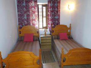 プエルト・デ・サン・ミゲルにあるEspaciosa Villa Con Piscina Privadaのピンクの枕が備わるベッドルームのツインベッド2台